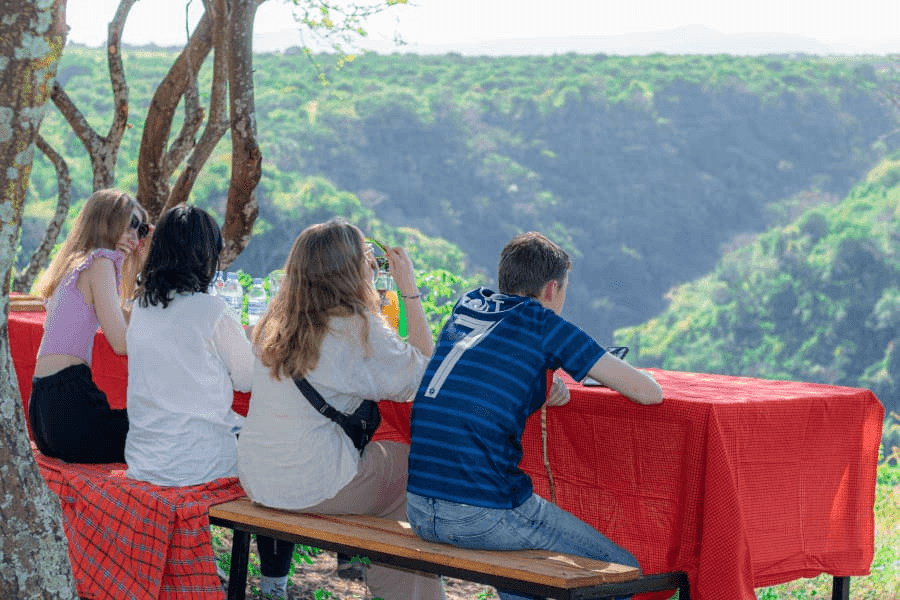 Visitors enjoying an outdoor table with a view of the Rift Valley